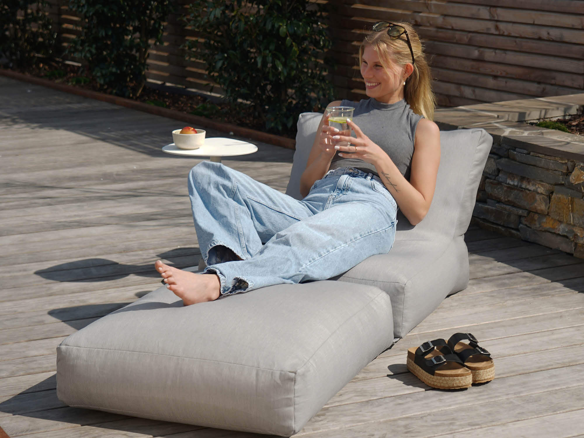 Outdoor Sitzsack 'Der Summerdream' in steingrau mit Model auf Holzterrasse 