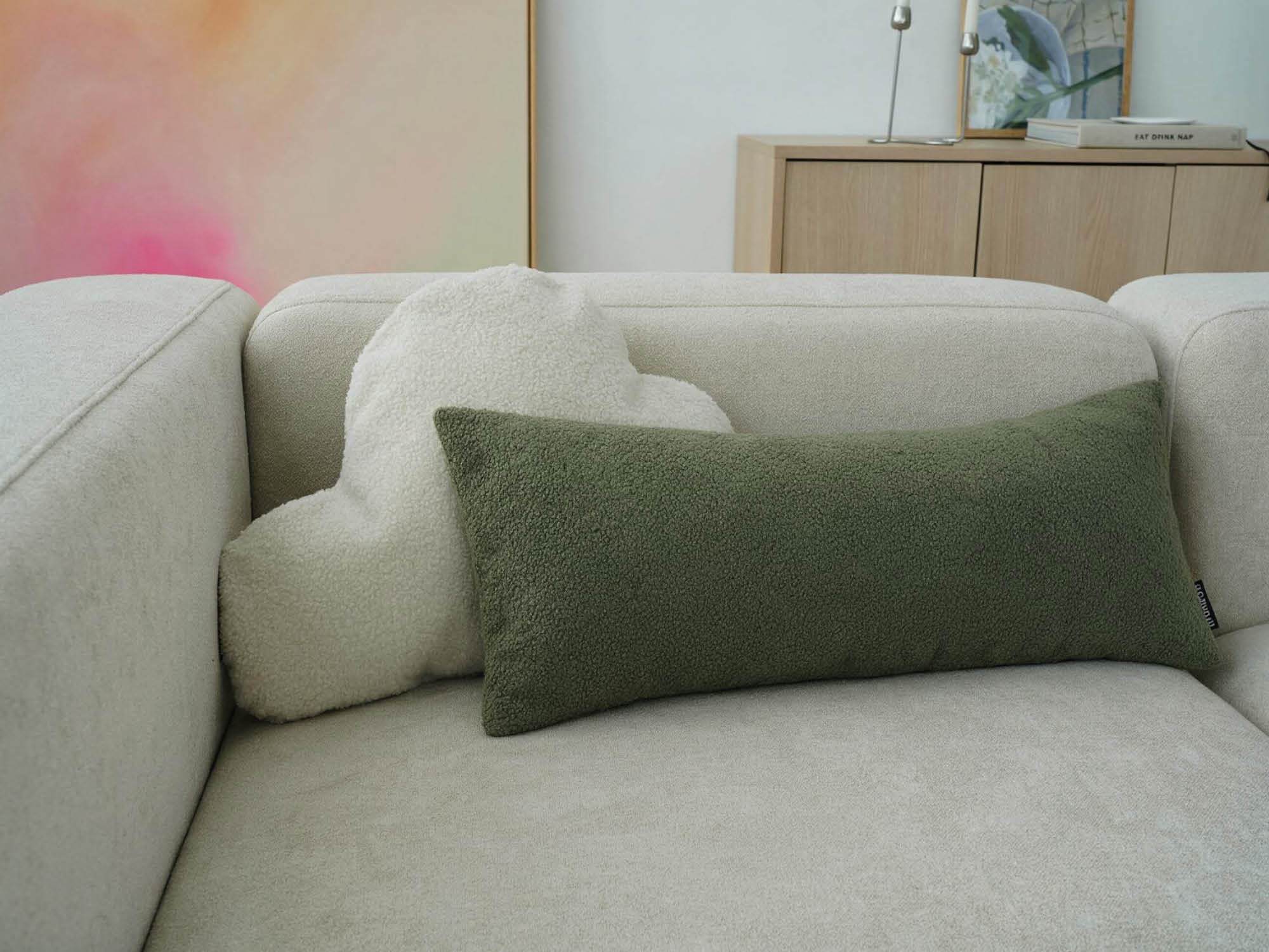 Bouclé Kissen 'Cloud' in ivory mit grünem Lendenkissen 'Line' auf beigen Sofa 